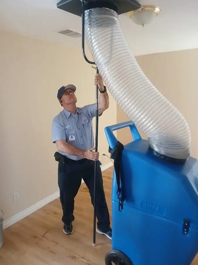 Furnace Tune-Up technician using HEPA equipment in Brenham
